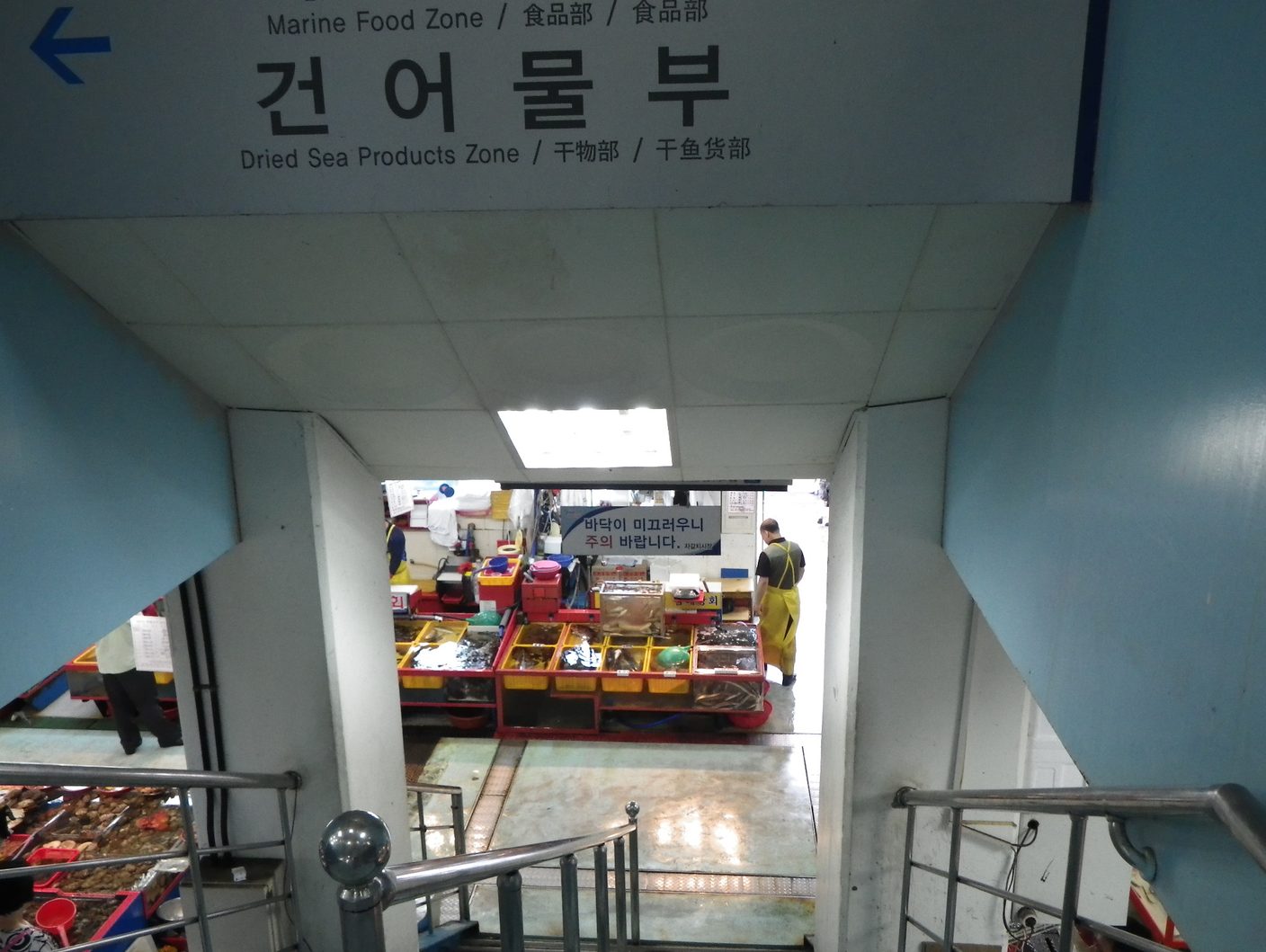 The Dried Sea Products Zone sign in Korean, English, Japanese and Chinese, above a stairway leading down into the market stalls